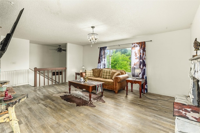 5900 Longview Dr, Missoula, MT 59803 - living area with wood finished floors, a fireplace with flush hearth, a textured ceiling, ceiling fan, and a chandelier