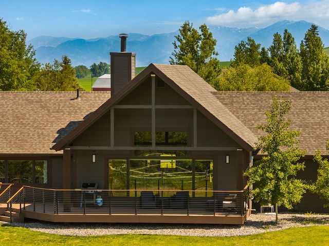 100 N Low Bench Rd, Gallatin Gateway, MT 59730 - rear view of property featuring a shingled roof, a chimney, and a deck with mountain view