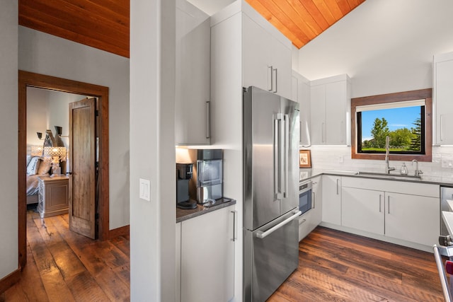 100 N Low Bench Rd, Gallatin Gateway, MT 59730 - kitchen with appliances with stainless steel finishes, wood ceiling, a sink, dark wood-style floors, and backsplash