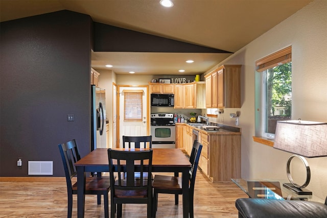 5334 Woodrow Ln, Lolo, MT 59847 - kitchen with stainless steel appliances, lofted ceiling, light brown cabinets, light wood-style floors, and recessed lighting