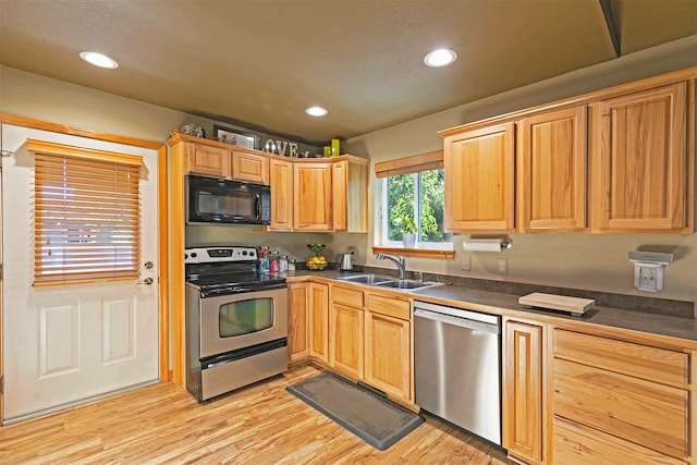 5334 Woodrow Ln, Lolo, MT 59847 - kitchen with appliances with stainless steel finishes, dark countertops, light wood-style floors, recessed lighting, and light brown cabinets