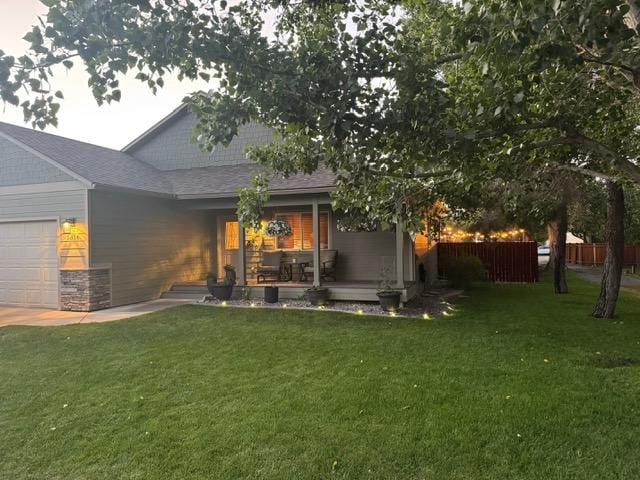 5334 Woodrow Ln, Lolo, MT 59847 - back of property featuring a garage, roof with shingles, and covered porch