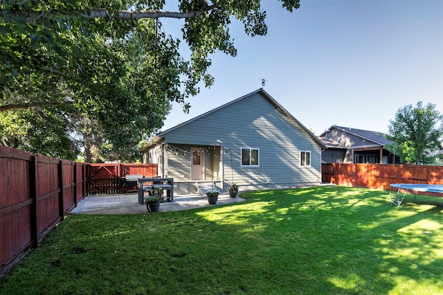 5334 Woodrow Ln, Lolo, MT 59847 - back of property with a trampoline, a patio, and a fenced backyard