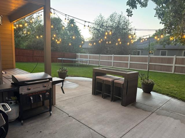 5334 Woodrow Ln, Lolo, MT 59847 - fenced backyard with a grill, a trampoline, and a patio area