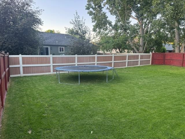 5334 Woodrow Ln, Lolo, MT 59847 - fenced backyard featuring a trampoline