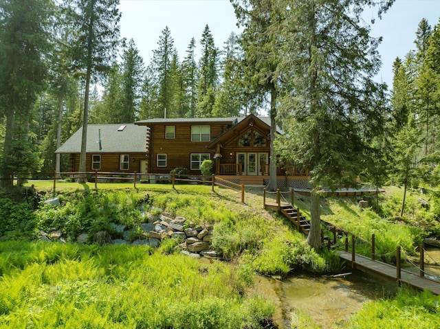 421 Swanson Lodge Rd, Troy, MT 59935 - rear view of house with log exterior, french doors, and a wooden deck