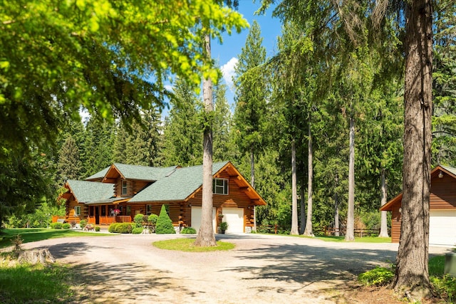 421 Swanson Lodge Rd, Troy, MT 59935 - log-style house featuring log siding, dirt driveway, roof with shingles, and a porch