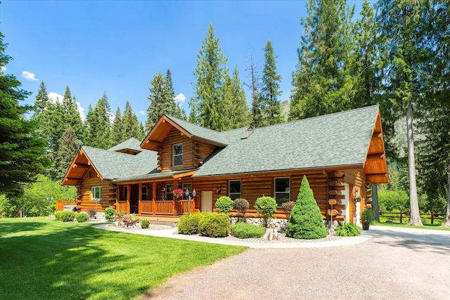421 Swanson Lodge Rd, Troy, MT 59935 - log cabin with log siding, a front yard, covered porch, and roof with shingles