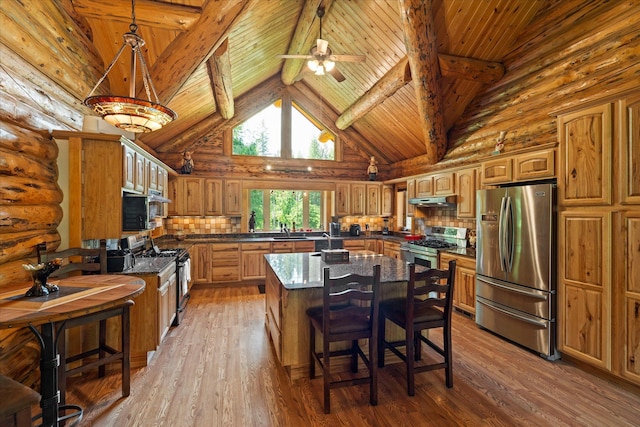 421 Swanson Lodge Rd, Troy, MT 59935 - kitchen featuring stainless steel appliances, log walls, wooden ceiling with exposed beams, under cabinet range hood, and a ceiling fan
