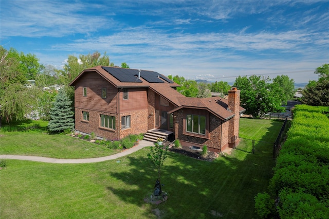 1520 Highland St, Helena, MT 59601 - rear view of property with roof mounted solar panels, a chimney, and brick siding