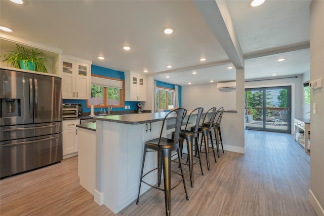 1520 Highland St, Helena, MT 59601 - kitchen featuring stainless steel fridge, plenty of natural light, white cabinetry, a breakfast bar area, and recessed lighting
