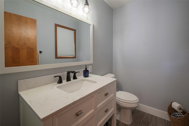 1520 Highland St, Helena, MT 59601 - half bathroom with toilet, wood finished floors, vanity, and baseboards
