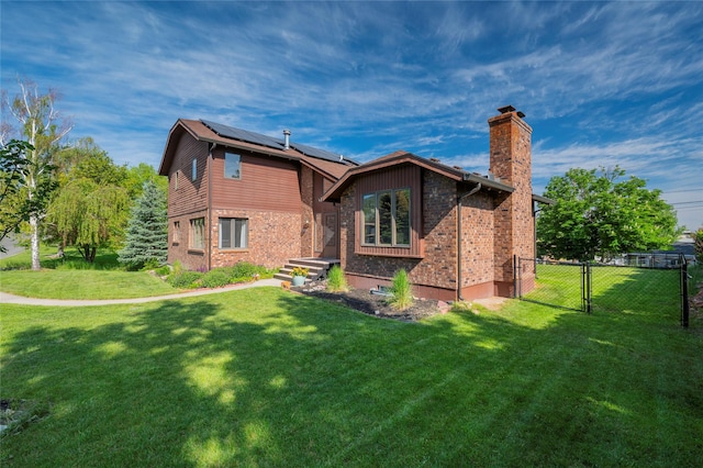 1520 Highland St, Helena, MT 59601 - rear view of house featuring a chimney, a gate, roof mounted solar panels, and brick siding