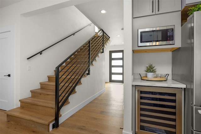 208 Cowboy Dr, Columbia Falls, MT 59912 - staircase with beverage cooler, wood finished floors, recessed lighting, and bar area