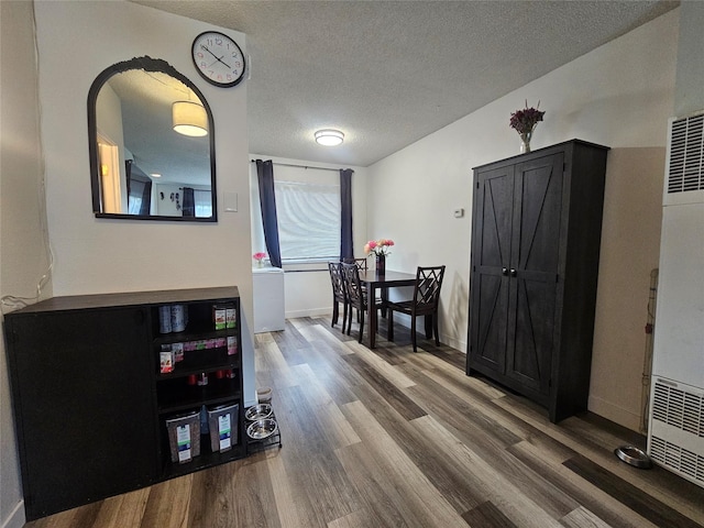 901 Rodgers St Unit 7, Missoula, MT 59802 - dining room with wood finished floors, a textured ceiling, a heating unit, and baseboards