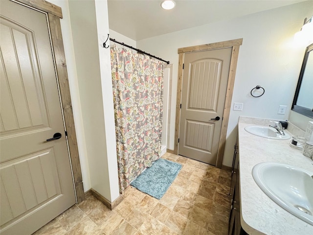 3075 Callaway Dr, East Helena, MT 59635 - bathroom with double vanity, a shower with shower curtain, baseboards, and stone finish floors
