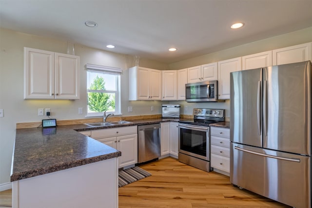 5196 Stallion Ridge Dr, Helena, MT 59602 - kitchen featuring appliances with stainless steel finishes, a sink, white cabinets, light wood-style flooring, and recessed lighting
