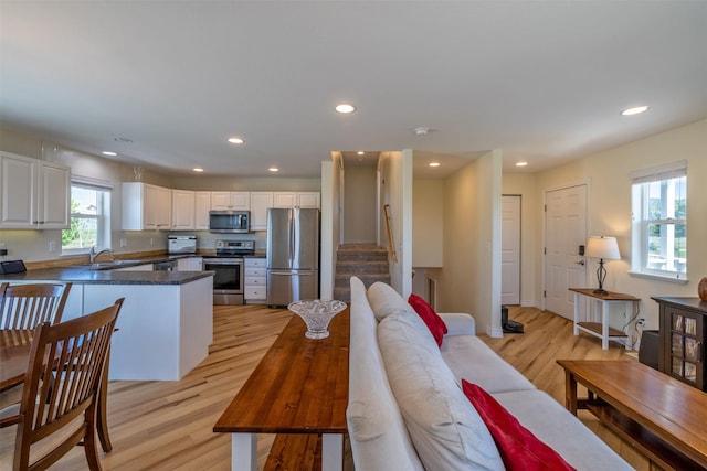 5196 Stallion Ridge Dr, Helena, MT 59602 - kitchen with appliances with stainless steel finishes, a sink, light wood-type flooring, a peninsula, and white cabinetry
