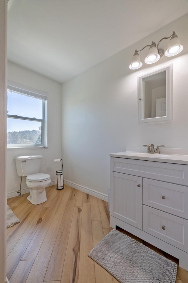 5196 Stallion Ridge Dr, Helena, MT 59602 - bathroom featuring toilet, vanity, wood finished floors, and baseboards