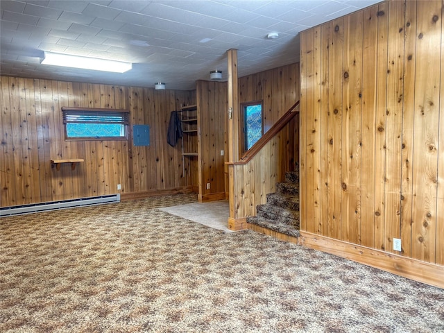 412 1st Ave E, Eureka, MT 59917 - carpeted spare room featuring a baseboard heating unit, wood walls, stairway, and baseboards