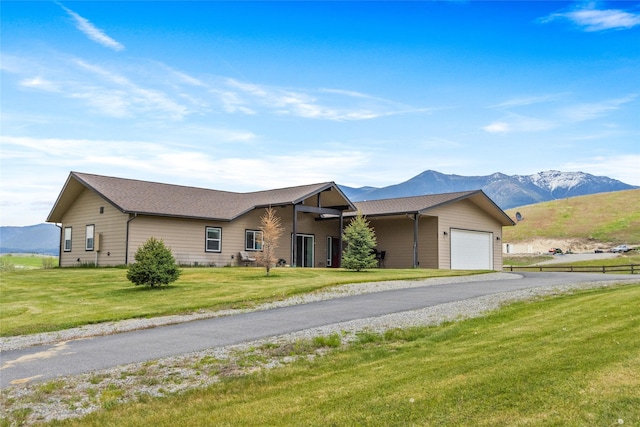 760 Lundeen Rd, Eureka, MT 59917 - ranch-style home with a garage, a mountain view, asphalt driveway, and a front lawn