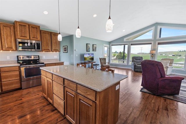 760 Lundeen Rd, Eureka, MT 59917 - kitchen with appliances with stainless steel finishes, open floor plan, brown cabinets, healthy amount of natural light, and vaulted ceiling