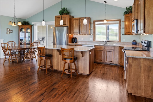 760 Lundeen Rd, Eureka, MT 59917 - kitchen with appliances with stainless steel finishes, brown cabinets, a sink, dark wood-style floors, and a center island