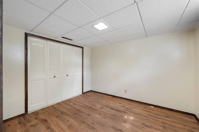 303 Sharon Ct, Anaconda, MT 59711 - unfurnished bedroom featuring wood finished floors, baseboards, a drop ceiling, and a closet