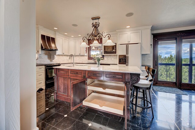 1644 Gold Rush Ave, Helena, MT 59601 - kitchen with ventilation hood, black range with gas stovetop, plenty of natural light, decorative backsplash, and recessed lighting