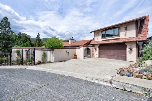 1644 Gold Rush Ave, Helena, MT 59601 - view of front facade featuring a garage, stucco siding, concrete driveway, a tile roof, and a chimney