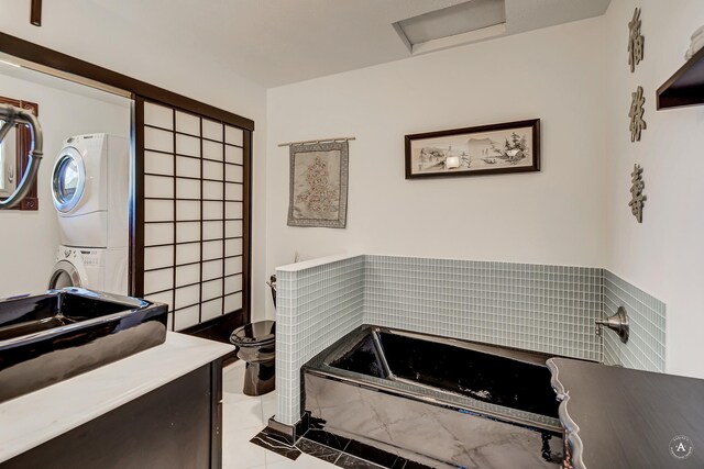 1644 Gold Rush Ave, Helena, MT 59601 - bathroom with stacked washing machine and dryer, a garden tub, toilet, vanity, and tile patterned floors
