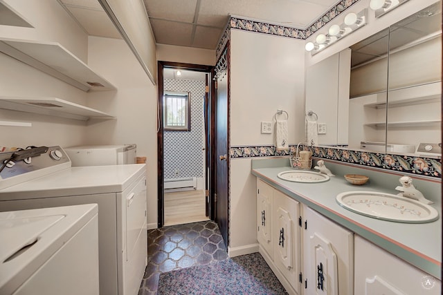 1644 Gold Rush Ave, Helena, MT 59601 - bathroom featuring a baseboard heating unit, double vanity, washer and clothes dryer, tile patterned floors, and baseboards