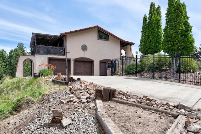 1644 Gold Rush Ave, Helena, MT 59601 - view of side of home featuring a balcony, stucco siding, concrete driveway, and an attached garage