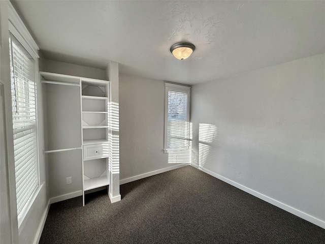 506 1st Ave E Unit A, B, C, Eureka, MT 59917 - unfurnished bedroom featuring baseboards, dark carpet, and multiple windows