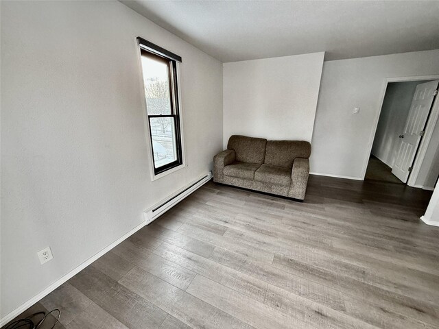 506 1st Ave E Unit A, B, C, Eureka, MT 59917 - living area featuring a baseboard radiator, wood finished floors, and baseboards