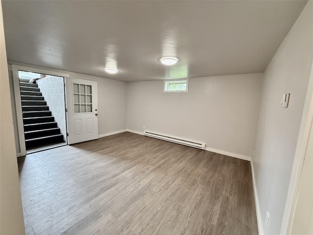 506 1st Ave E Unit A, B, C, Eureka, MT 59917 - below grade area featuring a baseboard radiator, wood finished floors, stairs, and baseboards