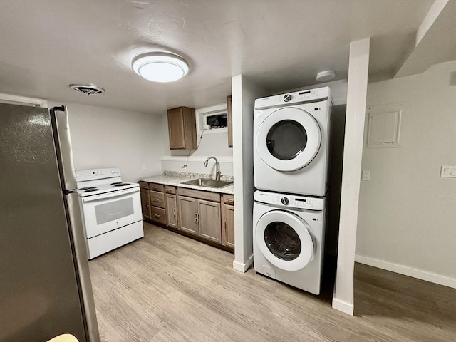 506 1st Ave E Unit A, B, C, Eureka, MT 59917 - laundry room with stacked washer and clothes dryer, light wood-type flooring, and baseboards
