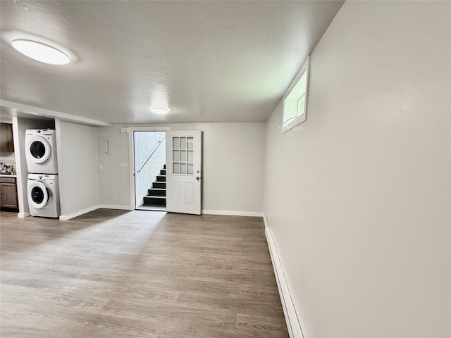 506 1st Ave E Unit A, B, C, Eureka, MT 59917 - laundry area featuring stacked washer and clothes dryer, light wood-style flooring, baseboards, and baseboard heating