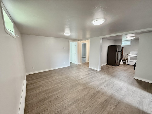 506 1st Ave E Unit A, B, C, Eureka, MT 59917 - basement with freestanding refrigerator, wood finished floors, baseboards, and a baseboard heating unit