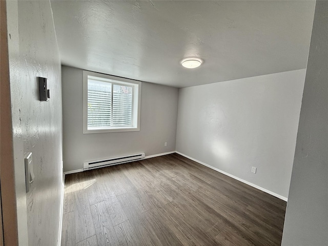 506 1st Ave E Unit A, B, C, Eureka, MT 59917 - empty room with a baseboard radiator, dark wood-type flooring, and baseboards