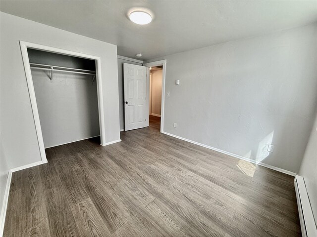 506 1st Ave E Unit A, B, C, Eureka, MT 59917 - unfurnished bedroom featuring baseboard heating, wood finished floors, a closet, and baseboards
