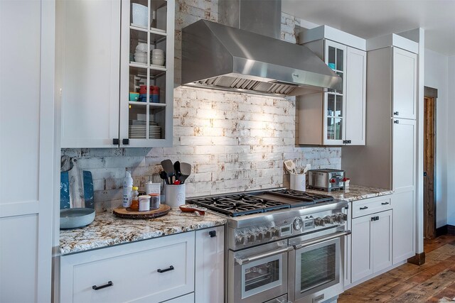 45331 Turnquist Rd, Ronan, MT 59864 - kitchen featuring double oven range, wall chimney exhaust hood, decorative backsplash, and white cabinets