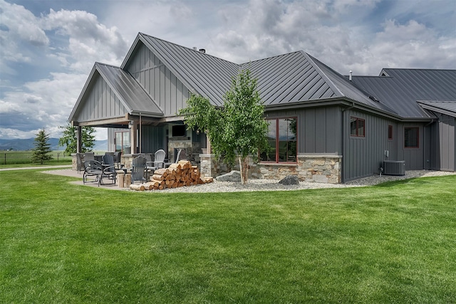 45331 Turnquist Rd, Ronan, MT 59864 - rear view of property with board and batten siding, a standing seam roof, central AC unit, and a yard