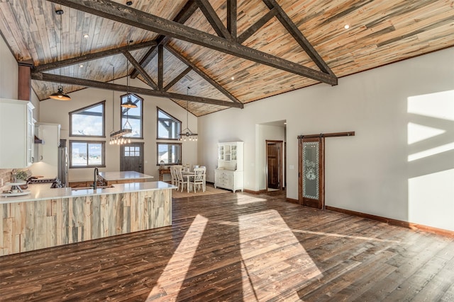 5130 Cameron Rose Ln, Stevensville, MT 59870 - kitchen featuring high vaulted ceiling, dark wood-style floors, light countertops, white cabinetry, and a peninsula