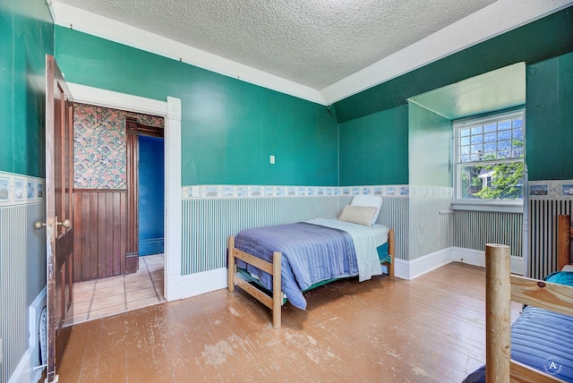 860 Hiawatha St, Helena, MT 59601 - bedroom with wainscoting, a textured ceiling, and wood finished floors