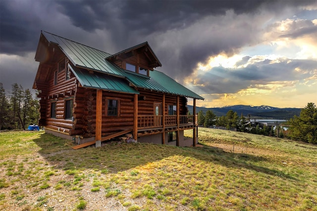 30 Douglas Lee Ln, Anaconda, MT 59711 - property exterior at dusk with log siding, a standing seam roof, a metal roof, a yard, and a deck with mountain view