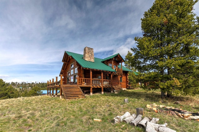 30 Douglas Lee Ln, Anaconda, MT 59711 - rear view of house featuring log siding, a chimney, a wooden deck, and a metal roof