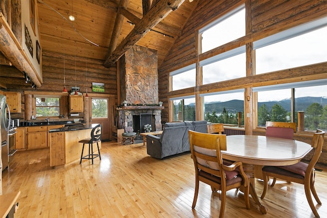 30 Douglas Lee Ln, Anaconda, MT 59711 - dining area featuring high vaulted ceiling, a mountain view, a wood ceiling with exposed beams, light wood-style flooring, and a fireplace