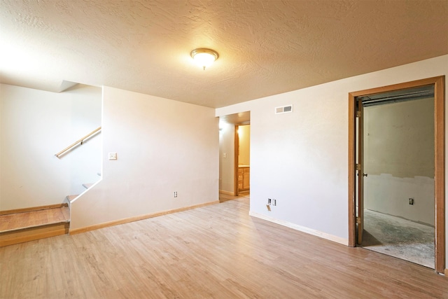 470 Strand Ave, Missoula, MT 59801 - spare room featuring light wood finished floors, a textured ceiling, and stairway