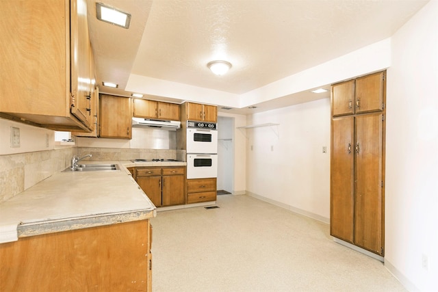 470 Strand Ave, Missoula, MT 59801 - kitchen with brown cabinets, light countertops, cooktop, and under cabinet range hood
